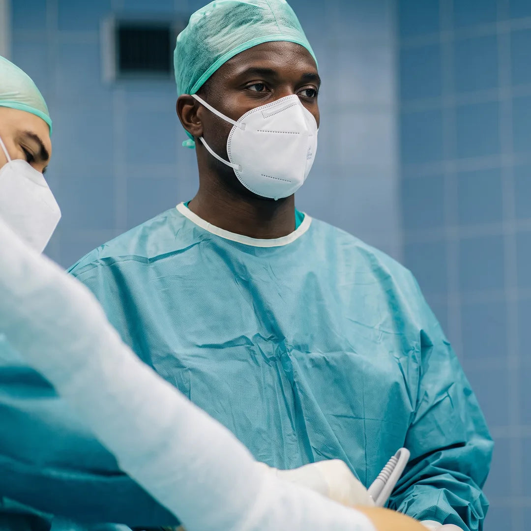 Surgical staff in gowns and masks during a procedure in an operating room