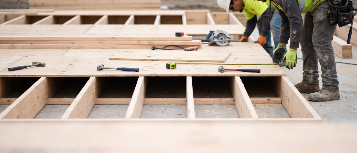 Construction and Skilled Trades. A framed floor plate at mid-build, tools set down in working order.
